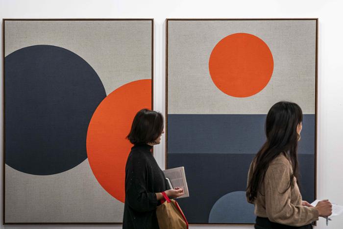 Dos personas mirando a unos circulos concéntricos de colores ARCO