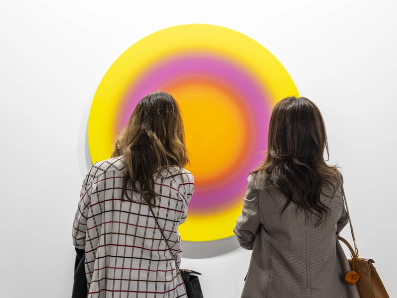 Dos personas mirando a unos circulos concéntricos de colores ARCO