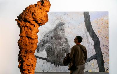 Person looking at a painting of a gorilla at ARCOmadrid
