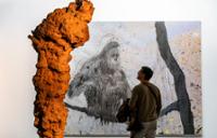 Person looking at a painting of a gorilla at ARCOmadrid