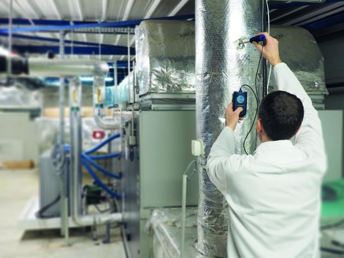 A professional measuring air quality in a laboratory