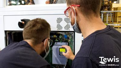 Two operators working on a refrigeration equipment.
