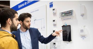 Two people observe a system of regulation and domotics for air conditioning.