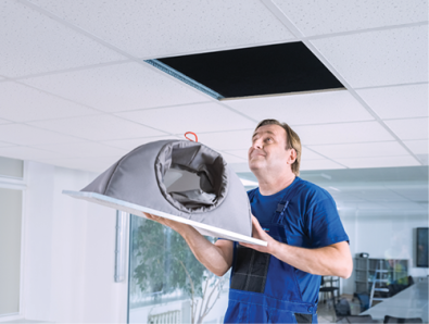An operator installing the FabricAir textile ceiling diffuser in an office.