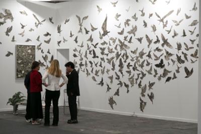 Visitantes observan una instalación artística de aves en la feria de arte contemporáneo ESTAMPA