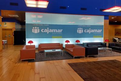 lounge with sofas and a screen with the logo of cajamar