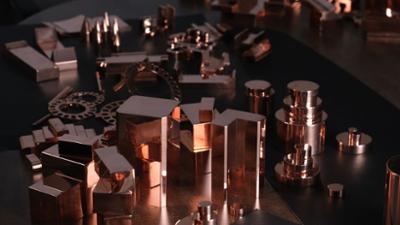 Piezas y componentes metálicos de cobre expuestos sobre una mesa para procesos de fabricación y diseño industrial.