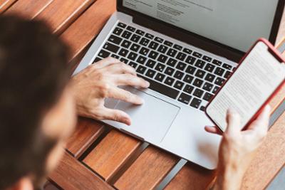 Two women smile in front of a computer