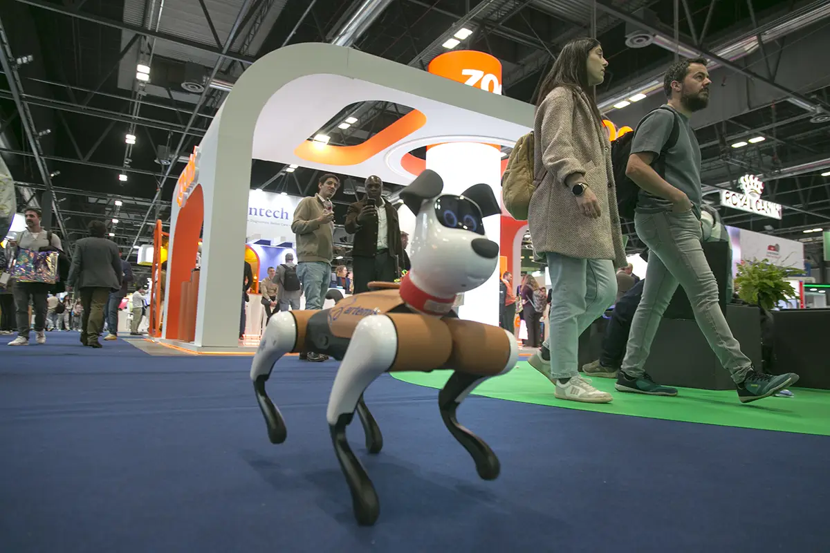 Personas hablado en un stand y detras de ellos estanterias con comida de perro