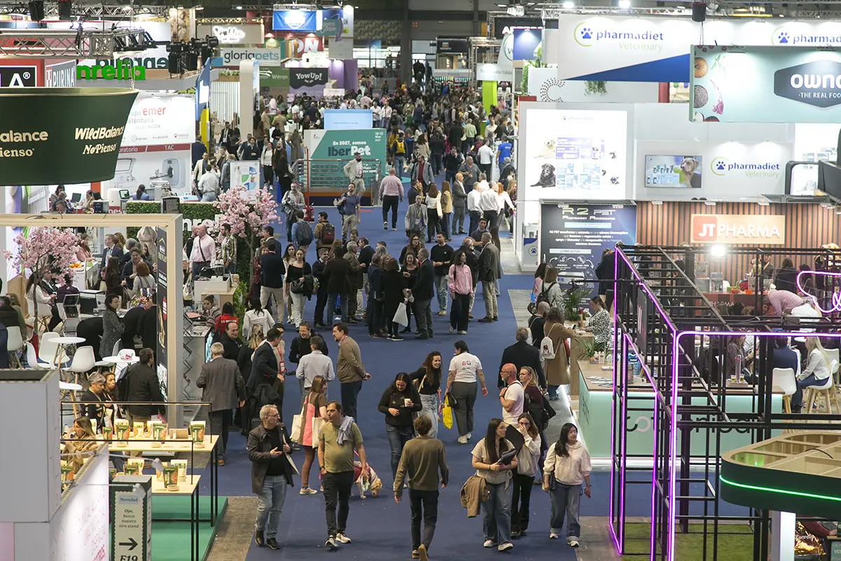 Visitante obteniendo información productos con un expositor en un stand.