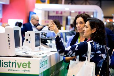 Two women chatting in front of a fair booth