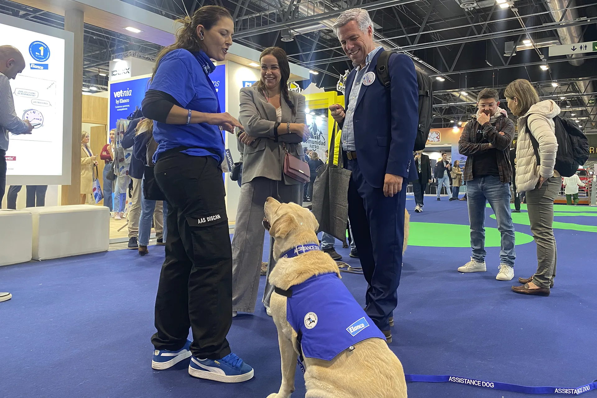 Personas hablando con asistente de perro guia y el perro.