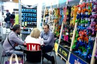Visitantes hablando en un stand de correas y juguetes para perros