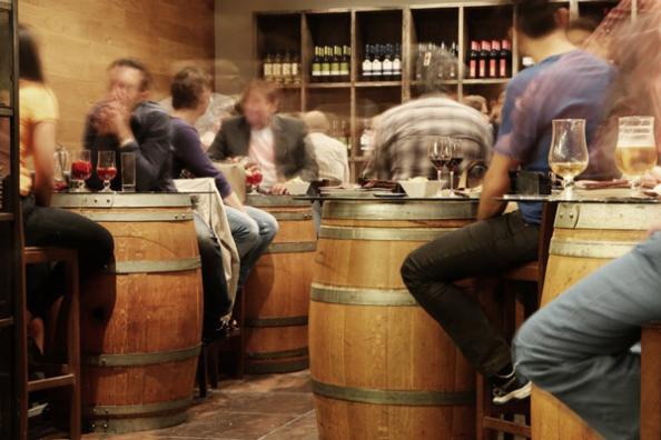 gente sentada comiendo frente a barriles