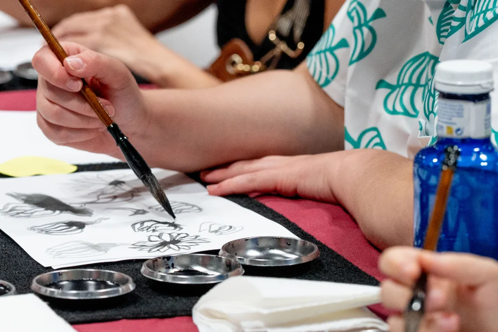 Asistentes practicando caligrafía Japonesa en la Japan Weekend Madrid