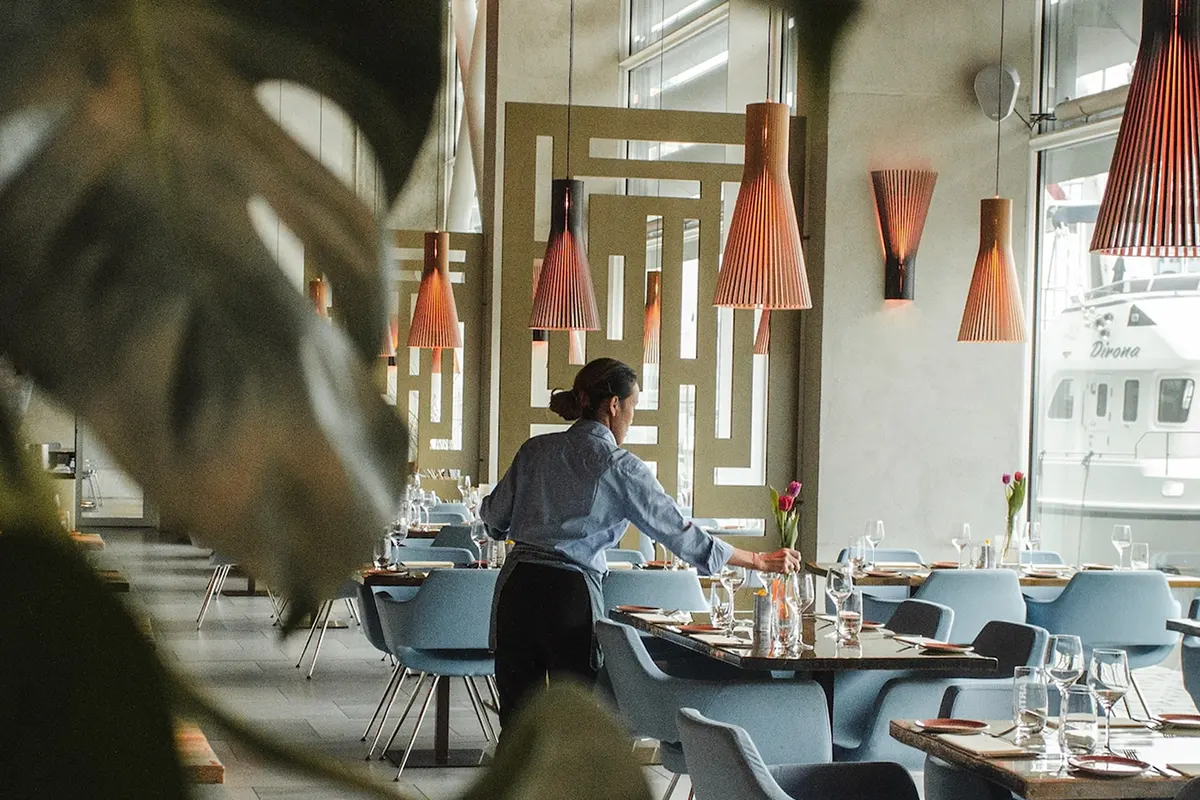 Waitress decorating restaurant tables