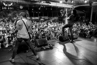 Cantante y guitarrista de espaldas tocando delante del publico con padres y niños en Rock en Familia