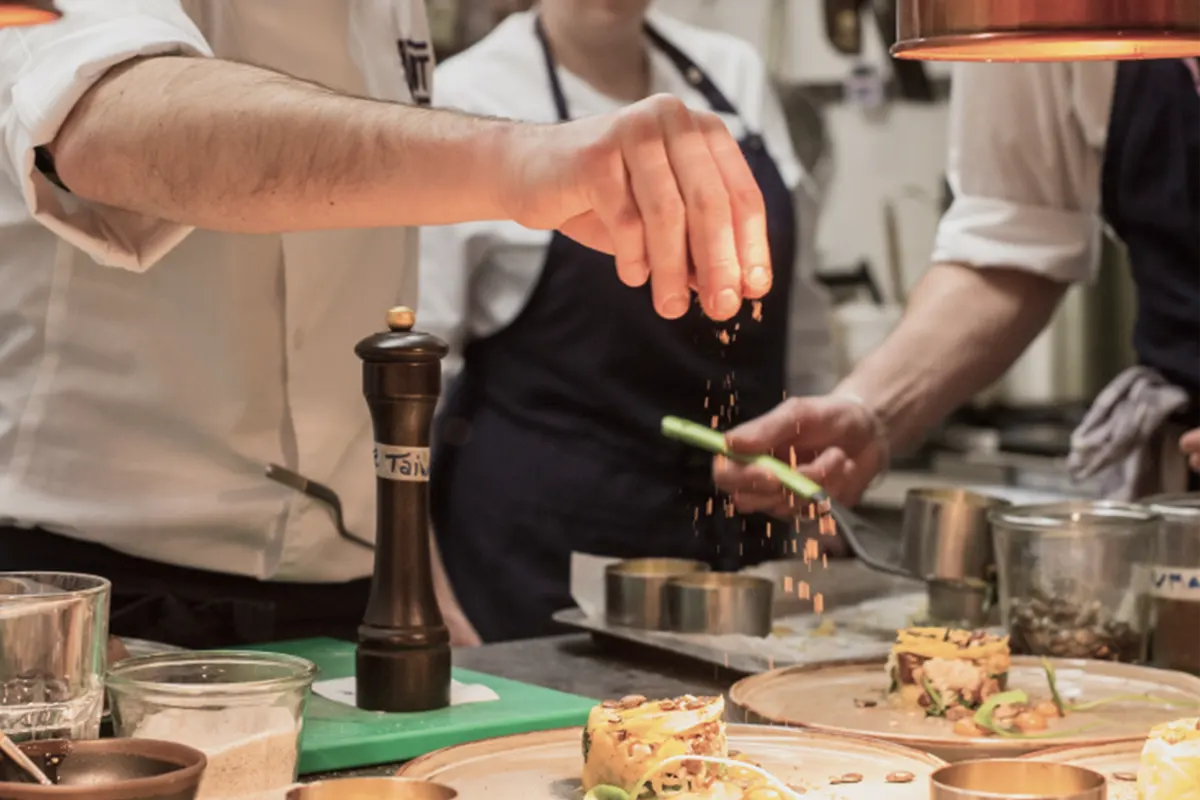 Cocineros de Starlite sazonando un plato