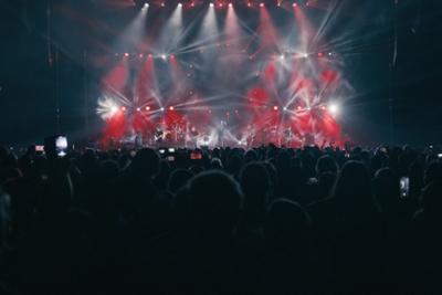 Concierto de The Australian Pink Floyd con luces rojas en el escenario y mucha gente bailando