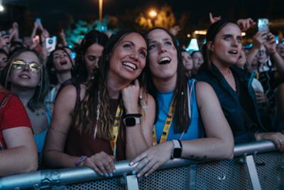 dos chicas abrazadas difrutando de un concierto de Love The Twenties de noche