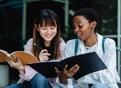 Two girls with notebooks reviewing before the exam
