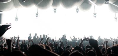 EScenario del festival Time Warp con luces blancas y gente bailando