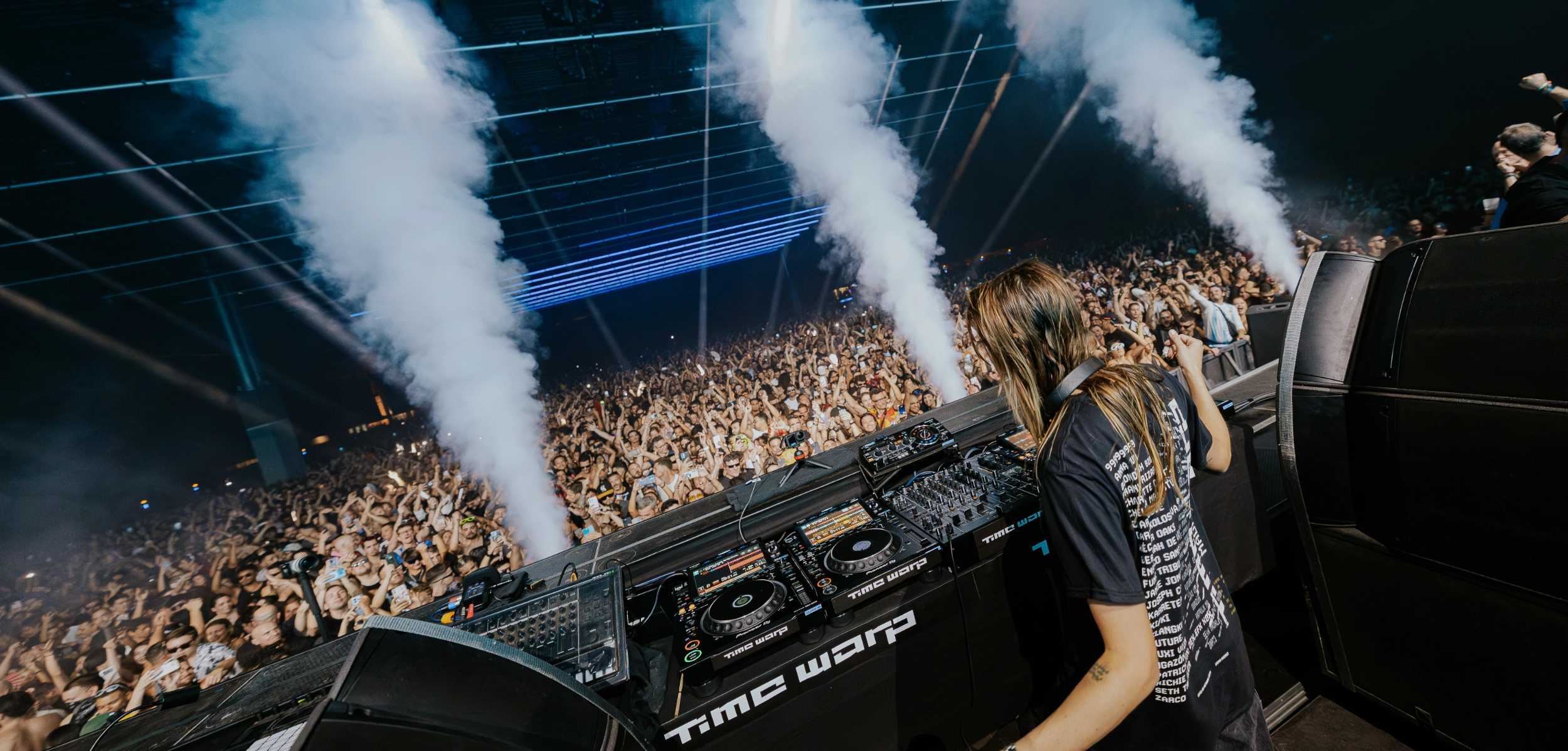 EScenario del festival Time Warp con luces blancas y gente bailando