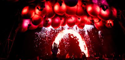 escenario del festival Time Warp con luces rojas encima y gente bailando