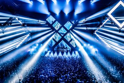 Escenario de Don’t Let Daddy Know con una multitud vibrante y luces espectaculare