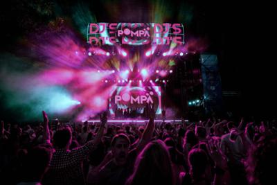 Escenario de Pompa 360 con carteles luminosos y gente bailando