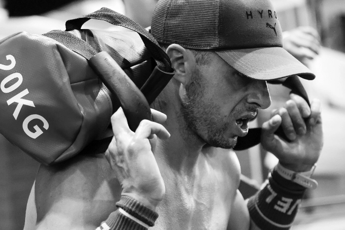 foto en blanco y negro de chico llevando peso para las pruebas de Hybrid Day