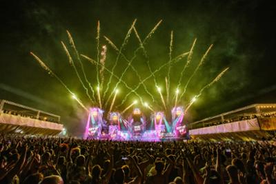 foto de un escenario del festival Love The 90s de noche con fuegos artificiales y gente bailando