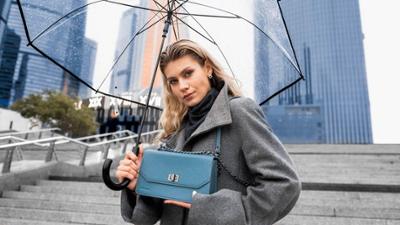 Mujer con un bolso azul con cadena