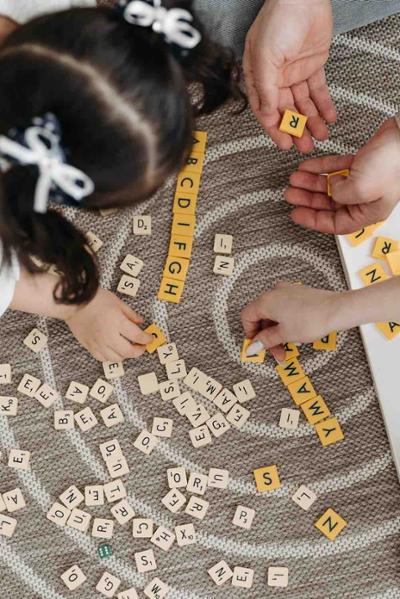 Niña jugando juego educativo con su familia