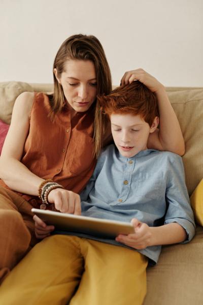 Niño usando herramientas digitales educativas con su madre