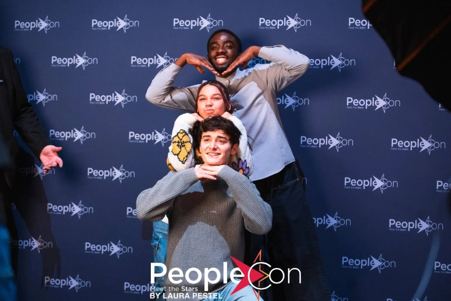 Noah and Caleb at the Stranger Things event posing with a fan for a photo