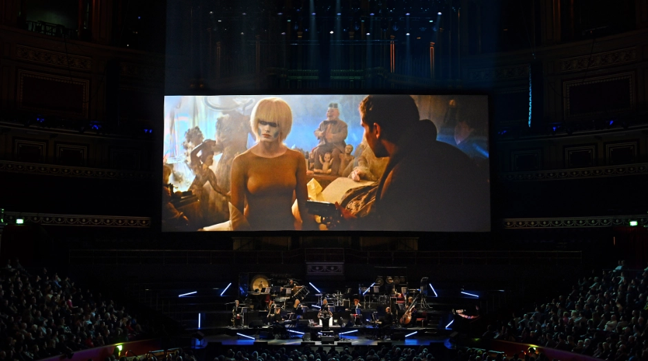 orquesta encima del escenario tocando musica de Blade Runner Live con escena de la película