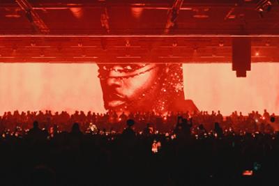 Pantalla de un concierto Black Coffee con una imagen suya en pantalla gigante y con todo el público bailando