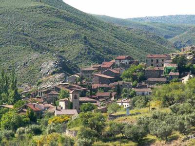 Patones de Arriba, pueblo tradicional de la Sierra de Madrid con montañas al fondo