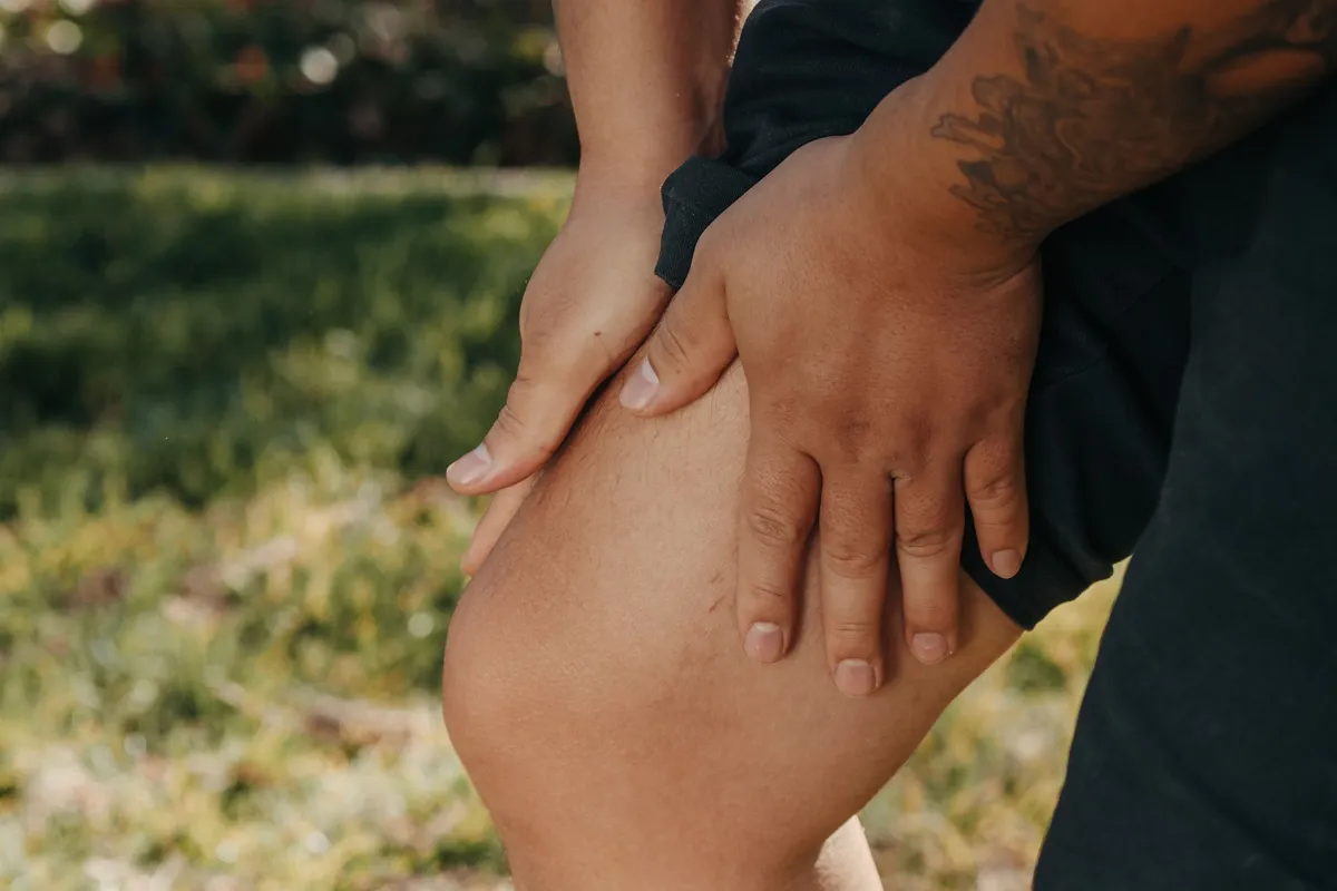Persona doliéndose de la rodilla