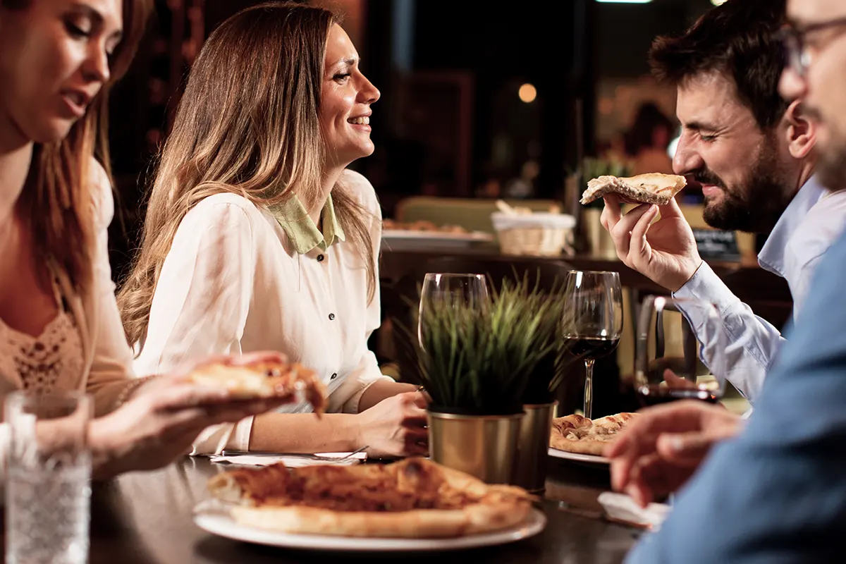 People eating pizzas and drinking wine