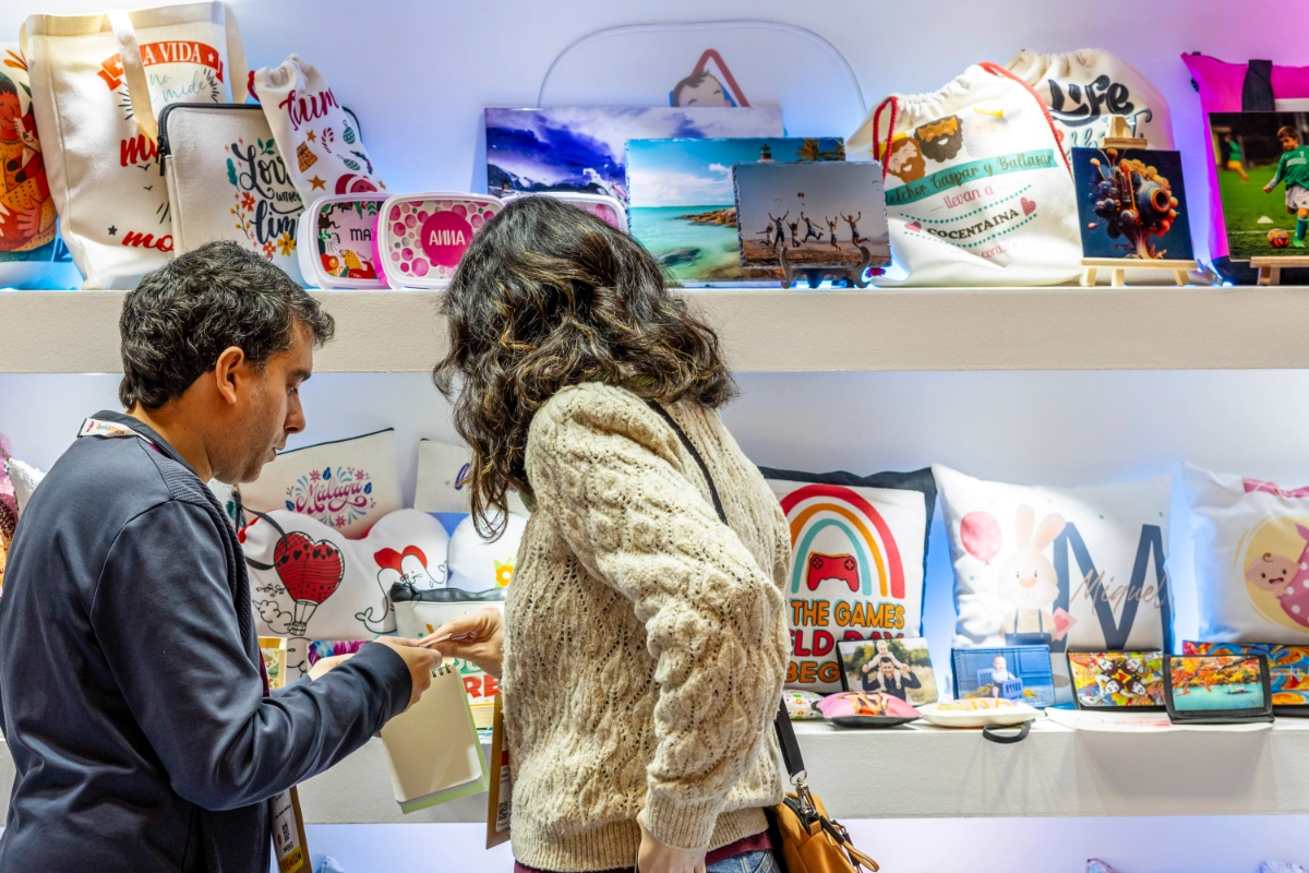 personas mirando cojines y bolsas de tela impresos en C!Print