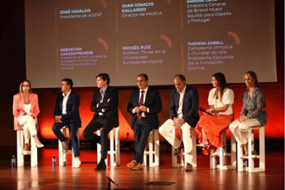 Ponentes sentados escuchando en el escenario de Sports Summit