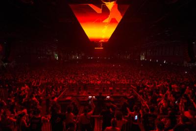 Público en el blackworks-festival bailando con el fondo con luces amarillas