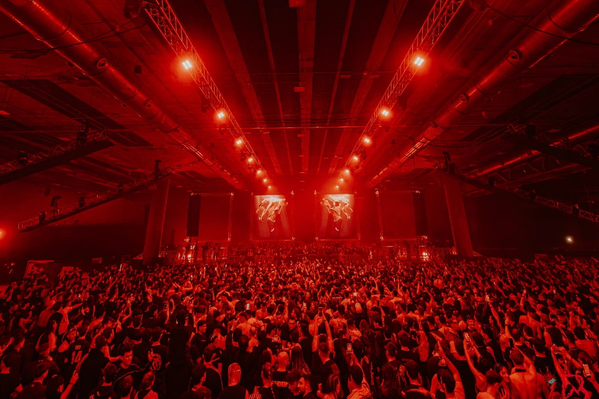 Público en el blackworks-festival bailando con el fondo con luces amarillas