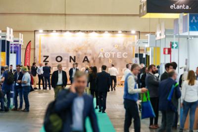 Visitantes en AOTEC con stands al fondo