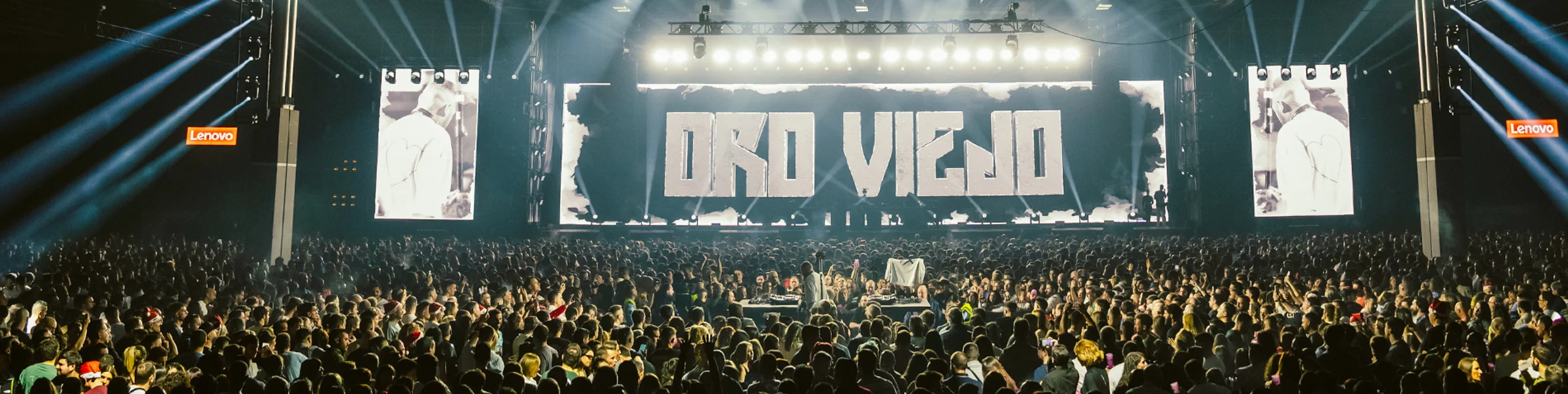 Oro viejo tardebuena hero con una foto del escenario con el nombre del evento