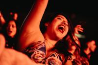 chica con brazo en alto entre el público