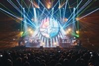 Concierto de The Australian Pink Floyd cantando sobre el escenario con un escudo y luces