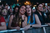 dos chicas abrazadas difrutando de un concierto de Love The Twenties de noche